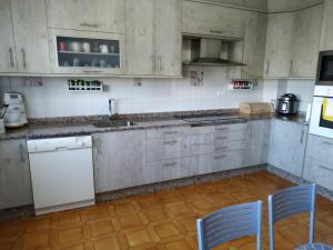 a kitchen with white appliances and blue chairs in it at Villa Sara in Ribadeo