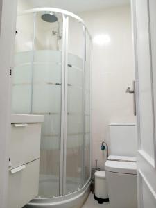 a white bathroom with a shower and a toilet at Cabo de Palos apartamento vacacional in Cabo de Palos