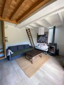 a living room with a blue couch and a fireplace at L’escapade, coeur de la nature in Saint-Hippolyte-du-Fort
