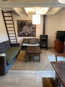 a living room with a couch and a table at L’escapade, coeur de la nature in Saint-Hippolyte-du-Fort +48 photos