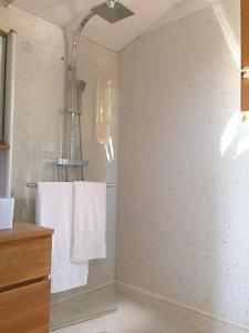 uma casa de banho com toalhas brancas penduradas numa parede em Chalet Loire proche Sancerre em Cosne Cours sur Loire