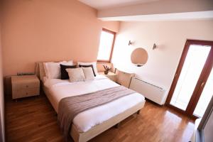 a bedroom with a bed with white sheets and pillows at Petrovski's Residence in Bitola