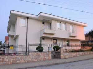 a large white house with a brick wall at Petrovski's Residence in Bitola