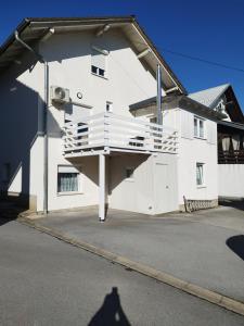 a white building with a balcony on the side of it at Apartments Matijevic in Grabovac