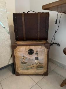 an old trunk with a picture of a lighthouse on it at Casa Chichina in Guardialfiera