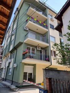 d'un grand bâtiment avec un balcon et des fleurs. dans l'établissement Luxurious 1BR Apartment with Elevator Near Lake Ohrid, à Ohrid