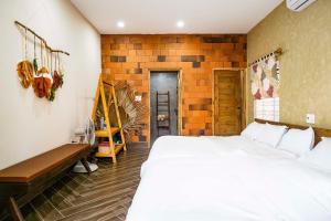 1 dormitorio con cama blanca grande y banco en Hiên Cát homestay, en Hue