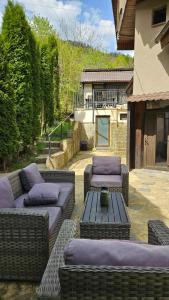 d'une terrasse avec des canapés et une table avec des oreillers violets. dans l'établissement Pensiunea Bia Papadia, à Bicaz