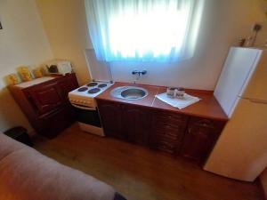 a kitchen with a sink and a stove and a window at Etno House Mira in Virpazar