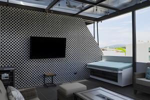 un salon avec une télévision sur un mur dans l'établissement New! Fluvial Casa con Alberca, à Bucerías