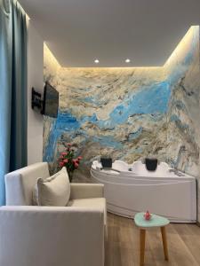 a living room with a white tub and a painting at Ilio Boutique Hotel in Ksamil