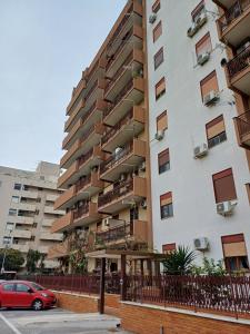 a red car parked in front of a tall building at A casa di zia Maria in Palermo