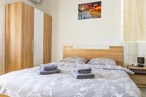 een slaapkamer met een bed met handdoeken erop bij Casa DARYA-24h Check-in in Boekarest