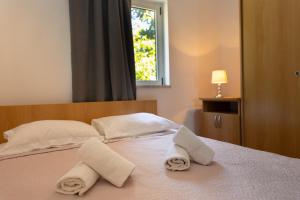 a bedroom with two towels on a bed with a window at Apartmani Tona in Gradac