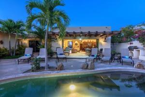 un cortile con piscina, sedie e una casa di Tooker Casa del Sol San José del Cabo, 5 Bedroom Private Pool and Spa a San José del Cabo