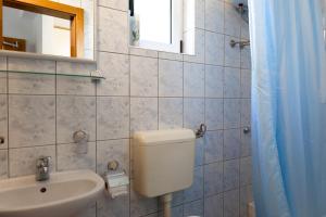 a bathroom with a toilet and a sink and a mirror at Apartmani Tona in Gradac