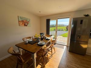 une salle à manger avec une table en bois et un réfrigérateur dans l'établissement Drumhead Cottage Finzean, Banchory Aberdeenshire Self Catering with Hot Tub, à Finzean 31 autres photos