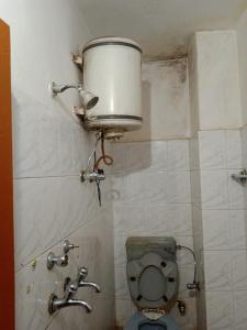 a bathroom with a toilet with a bucket on the wall at Aman guest house in Katra