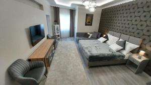 - un salon avec un lit, un canapé et une télévision dans l'établissement Cseresznyefa Vendégház, à Dorog