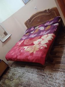a bed with a red comforter sitting on the floor at Aman guest house in Katra