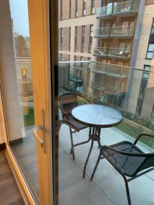 uma mesa e cadeiras numa varanda com uma janela em Reliance Apartment em Harlow