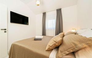 una camera da letto con un letto e una TV a parete di Luxurious beachfront Villa with sea view - by TA Leut Agency a Privlaka (Brevilacqua) Altre 26 foto