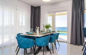 una sala da pranzo con un tavolo e sedie blu di Luxurious beachfront Villa with sea view - by TA Leut Agency a Privlaka (Brevilacqua)
