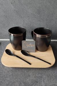 two cups and utensils on a wooden tray at L'Olivier de Lily in Voiron