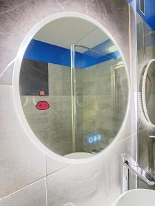 a mirror in a bathroom with a shower at L'Olivier de Lily in Voiron