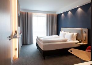 une chambre d'hôtel avec un lit et une fenêtre dans l'établissement Holiday Inn Express - Düsseldorf Airport, à Düsseldorf