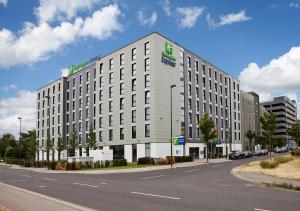 Holiday Inn Express - Düsseldorf Airport في دوسلدورف: مبنى ابيض كبير على جانب شارع