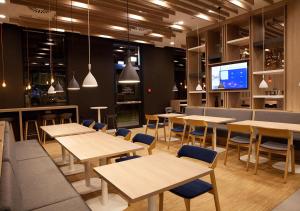 um restaurante com mesas e cadeiras e uma televisão em Holiday Inn Express - Düsseldorf Airport em Düsseldorf