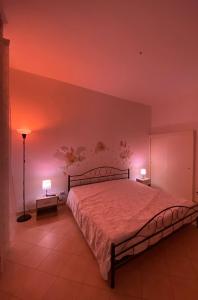 una camera da letto con un grande letto con illuminazione rosa di Casa Zaira a Castellana Grotte