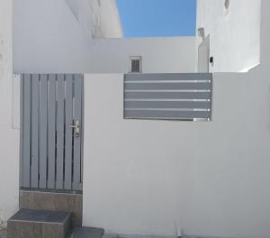 a white wall with a door and a window at Lava Guesthouse Prive in Karterados