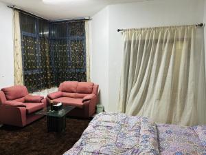 - une chambre avec deux chaises, un lit et une table dans l'établissement Premium Furnished Rooms Your Perfect Stay, à Ajman