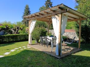 einen hölzernen Pavillon mit einem Tisch und Stühlen in der Unterkunft Residence Ruje in Prepotto