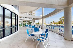 Un patio con mesas y sillas en un balcón. en Sunchase IV #907, en South Padre Island