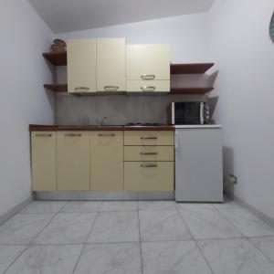 a kitchen with white cabinets and a white refrigerator at Case Francesco in Ragusa
