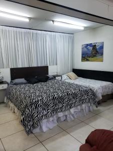 two beds in a bedroom with a zebra print bed at Hospedaje Shalom in Ushuaia