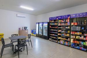 uma loja com mesa e cadeiras e máquinas de venda automática em Studios Charmosos Granja Brasil Itaipava em Itaipava