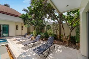 a patio with four chairs and a pool at VILLA BOND| 3 Bedrooms | Private Pool | 3 min to Naiharn Beach in Rawai Beach