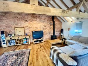 a living room with a brick wall at The Cart House - Rural Retreat in Hereford