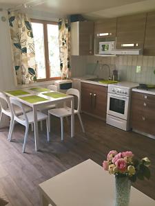 uma cozinha com uma mesa e cadeiras numa cozinha em Chalet Loire proche Sancerre em Cosne Cours sur Loire