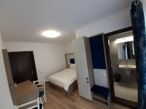 um pequeno quarto com uma cama e um lavatório em Pensiunea Stefania em Lacul Roșu