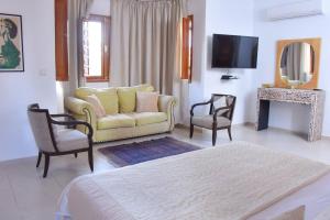 Villa in Central Marrakesh في مراكش: غرفة معيشة مع أريكة وكرسيين