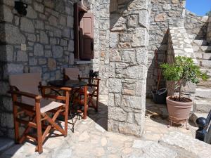 een patio met tafels en stoelen in een stenen gebouw bij Avgonima Family's Rooms Grandfather Michalis2 in Chios