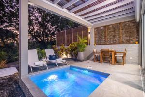 a swimming pool on a patio with a table and chairs at CocoonHuts Residences Martinique in Le Lamentin +26 photos