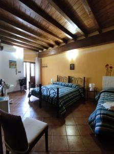 een slaapkamer met 2 bedden en een bank bij Affittacamere La Cartiera in Palazzo Adriano