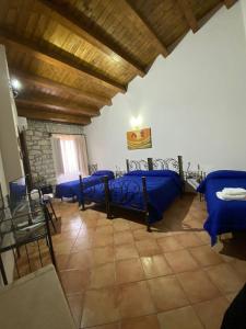 een slaapkamer met blauwe bedden in een kamer bij Affittacamere La Cartiera in Palazzo Adriano
