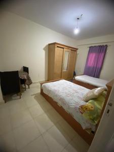 1 dormitorio con 1 cama y 1 silla en Home north cost en Sīdī Sālim